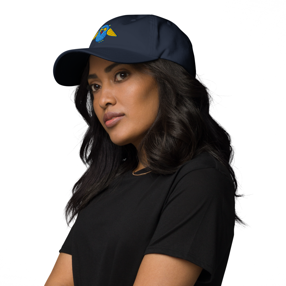 Baseballcap in Marineblau mit gesticktem Eulenlogo, getragen von einem Damenmodell in Dreiviertelansicht von links