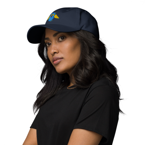 Baseballcap in Marineblau mit gesticktem Eulenlogo, getragen von einem Damenmodell in Dreiviertelansicht von links
